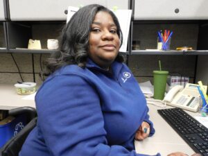 picture of Alex Quinn, Illinois JusticeCorps Fellow, sitting at her desk in the law library.